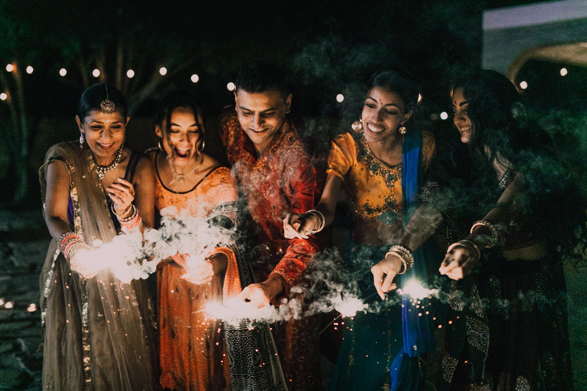 group of happy people holding sparklers